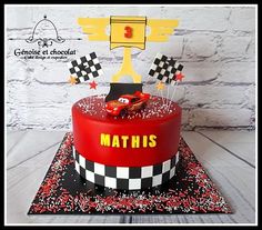 a birthday cake with cars on it and the words mathis written in red, white and black