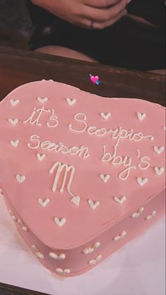 a pink heart shaped cake with white hearts on it and the words its scorpion season by 3