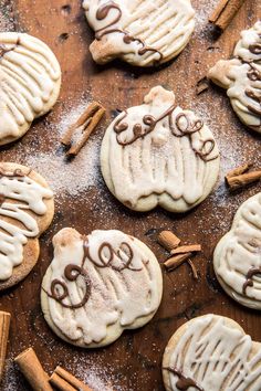 some cookies with icing and cinnamon sticks