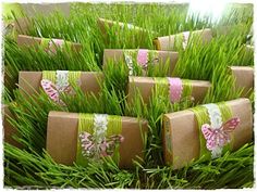 many wrapped presents sitting in the grass with pink butterflies on them and ribbons tied to them