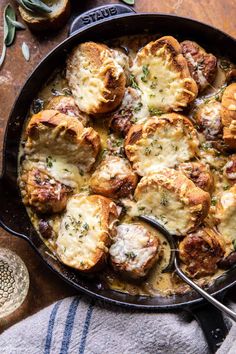 a cast iron skillet filled with cheesy bread and potatoes on top of a wooden table