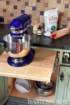 a blue mixer sitting on top of a wooden counter