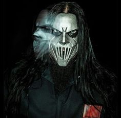 a man with long hair wearing a mask