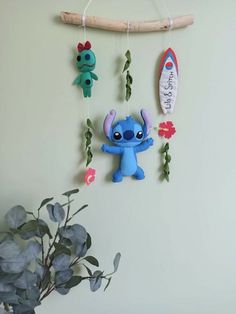 a wall hanging with some little stitchy toys on it