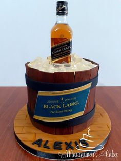 a bottle of black label sitting on top of a wooden barrel with ice in it