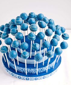 blue cake pops arranged in a bowl on top of each other with toothpicks sticking out of them