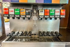 an automatic coffee machine with four cups on the front and three different colors on the back