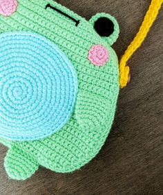 a crocheted frog coin purse with a yellow string attached to it's side