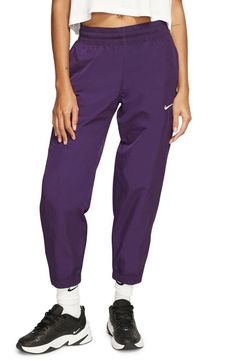 Nike NRG Women's Cropper Track Pants Style#: CQ4003-525 Purple Size: Medium (XS=0-2, S=4-6, M=8-10, L=12-14). These vintage-style track pants in smooth, swishy woven nylon are a throwback classic that feels fresh for today. High rise 26 1/2" inseam; 10" leg opening; 10 1/2" front rise; 15 1/2" back rise (size Medium) Elastic/drawcord waist Side zip pockets Side-zip elastic hems Mesh lining 100% nylon Machine wash, line dry Imported Jogging Pants Outfit, Snap Pants, Maternity Trousers, Comfy Sweatpants, Knit Shift Dress, Pants Style, Lace Sheath Dress, Jogging Pants, Fashion Joggers