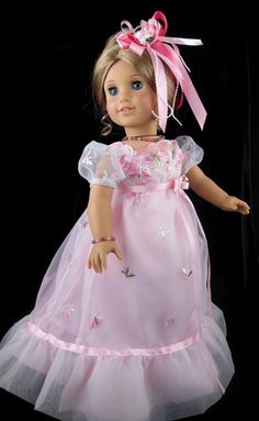 a doll wearing a pink dress with flowers on it's chest and headband