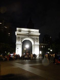 the people are standing in front of the arch at night with their lights on and there is no image to provide a caption for