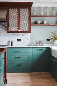 a kitchen with green cabinets and white counter tops