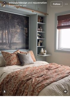 a bed sitting under a window next to a painting on the wall in a bedroom