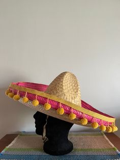 This is a vintage straw Mexican sombrero with hanging yellow tassels. Circa 1967, this hat was found at an estate sale and is in excellent condition.  If you have any further questions about this item, please feel free to reach out. "We don't see things as they are; we see them as we are." -Anais Nin **All of our items are sold AS-IS. We sell vintage items that are previously owned. Some flaws are to be expected. Please take your time to review all of the images carefully.  We clean and sanitize Mexican Hats, Mexican Sombrero Hat, Mexican Sombrero, Hanging Tassels, Sombrero Hat, Mexican Hat, Anais Nin, Vintage Mexican, Recycled Materials