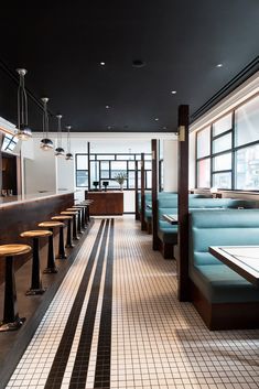 an empty restaurant with blue booths and tables