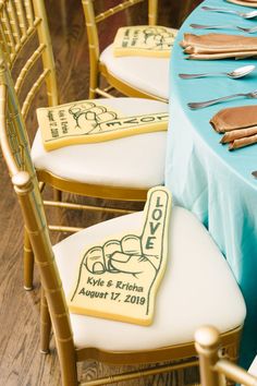 a table topped with lots of chairs covered in frosted cake next to a blue table cloth