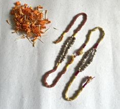 three different types of beads and flowers on a white surface with one being dried, the other is unpeeled