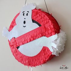 a red and white paper plate with a ghost hanging from it's side on a wall