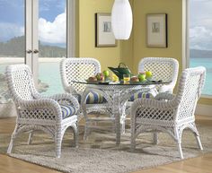 a dining room table with four chairs and a rug on the floor in front of it