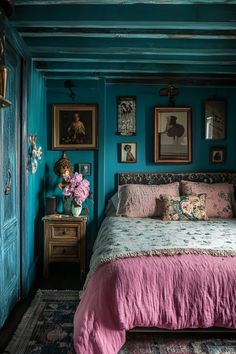 a bedroom with blue walls and pink bedspread on the bed is decorated with pictures