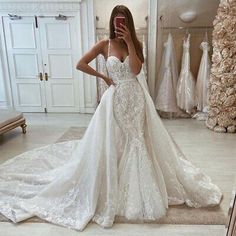 a woman in a wedding dress taking a selfie with her cell phone while standing in front of a mirror