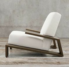 a white reclining chair sitting on top of a wooden floor next to a wall