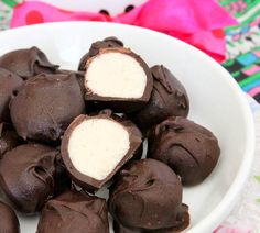 a white bowl filled with chocolate covered marshmallows on top of a table