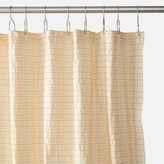 a curtain hanging on a metal rod in front of a white wall with a checkered pattern