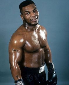 a close up of a shirtless man wearing boxing gloves