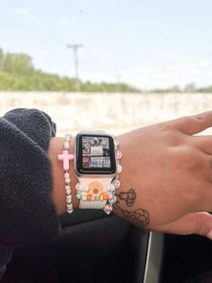 a person with tattoos on their arm and wrist holding an apple watch in her hand