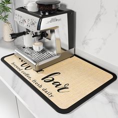 an espresso machine sitting on top of a counter next to a potted plant