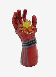 a hand that is holding a plant in it's palm and wearing a glove