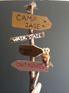 a sign post with several signs on it that read camp jase, wash state, reverse path, out houses