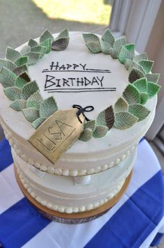 a birthday cake with leaves and a tag on it