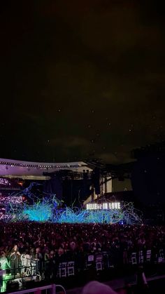 a large crowd is gathered at night to watch the show