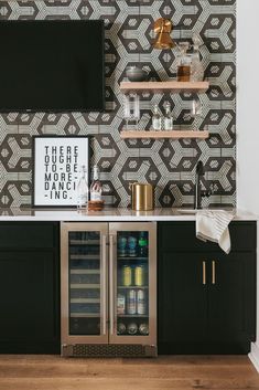 a black and white wall with shelves, wine coolers and other items on it