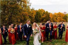 a bride and groom are surrounded by their wedding party in the fall colors at this outdoor wedding venue