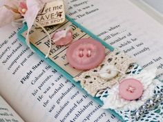 a bookmark made out of buttons and lace on top of an open book page