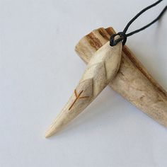 a wooden object with a black cord hanging from it's end on a white surface