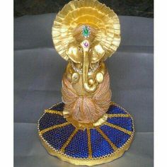 an elephant figurine sitting on top of a blue and gold plated stand