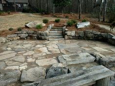 a stone patio with steps leading up to it