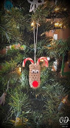 a christmas ornament hanging from the top of a tree with decorations on it