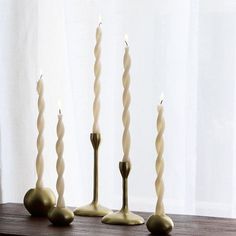 four candles are lined up on a table