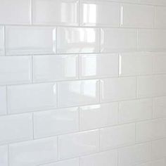 a bathroom with white tiles on the wall