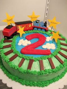 a birthday cake with a train on the top and two stars around it that says happy 2nd birthday