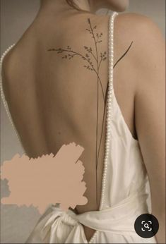 the back of a woman's dress with tattoos on her upper and lower back