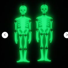 two neon green skeletons standing next to each other in front of a black background with an arrow pointing at them