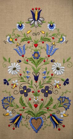 an embroidered wall hanging with birds and flowers on it's side, in the shape of a tree