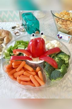 a plate filled with vegetables and crab on top of a table next to other foods