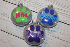 three personalized christmas ornaments with paw prints on them